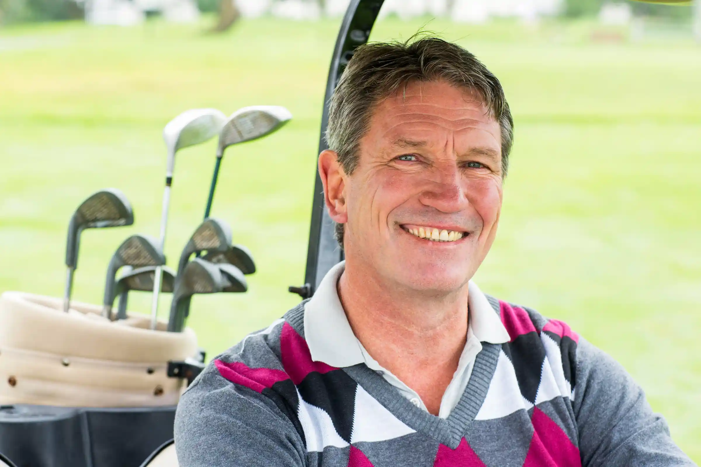 Smiling man in golf cart