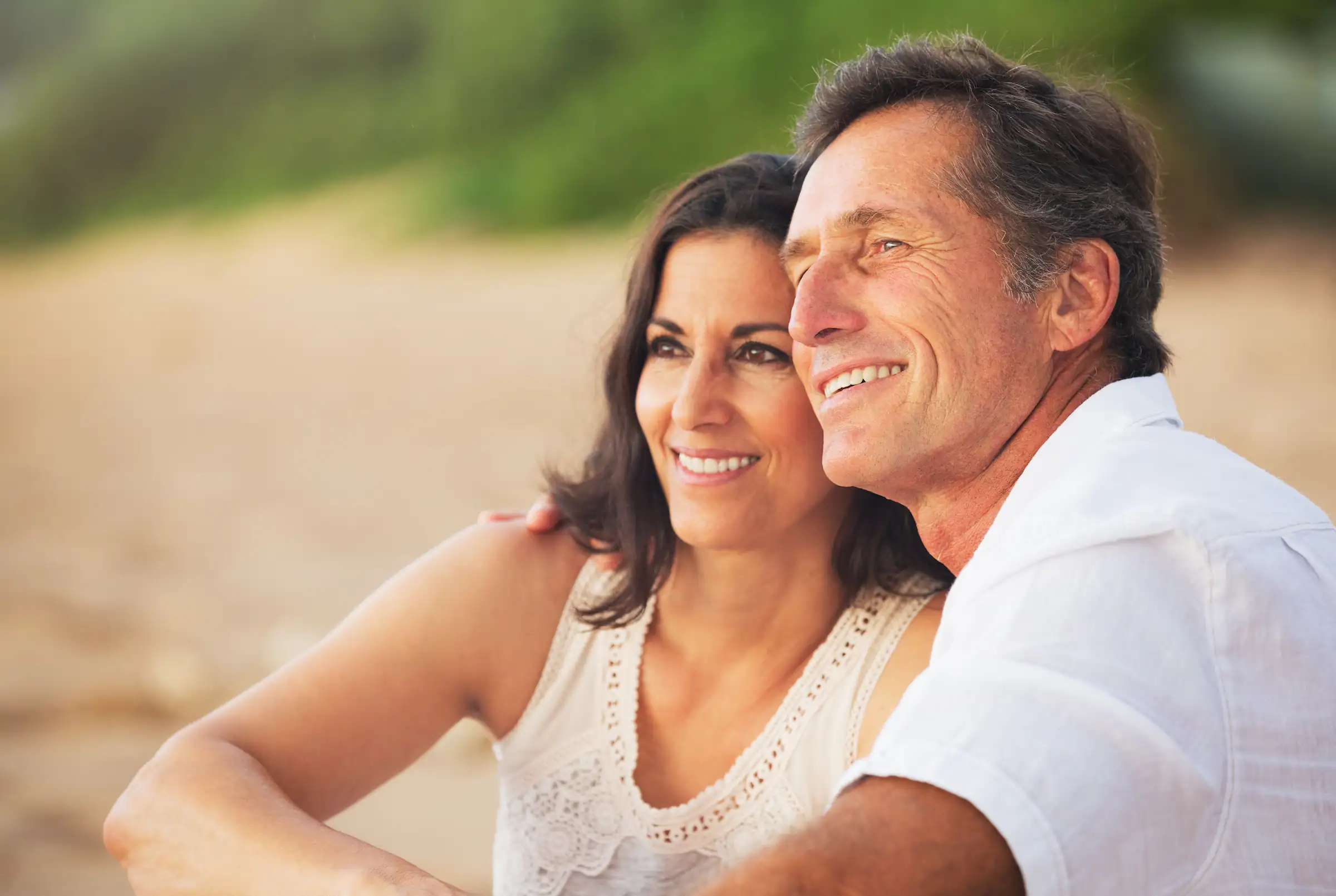 Mature happy couple sitting on the beach