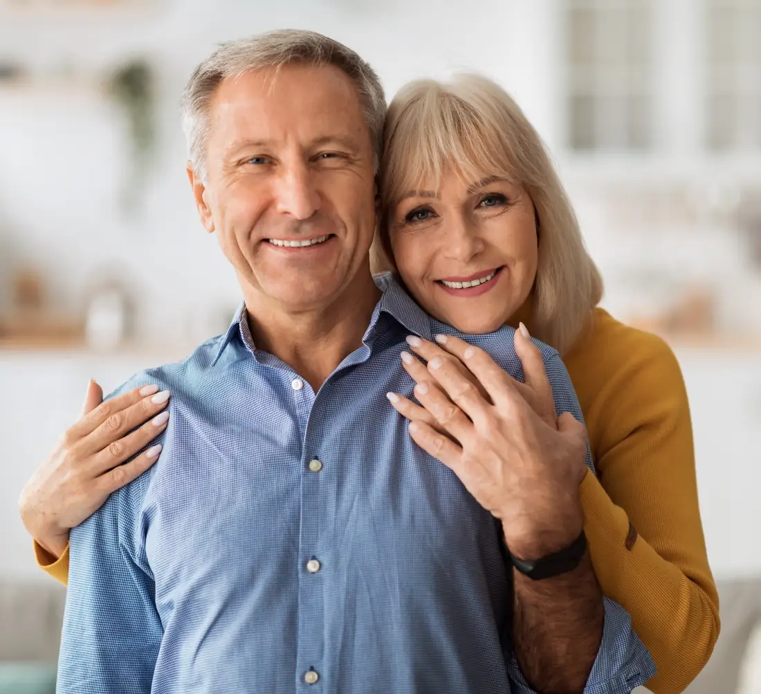 Senior Wife Embracing Husband Posing Together Standing In Kitchen